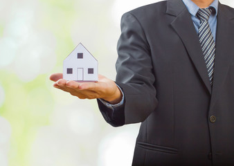 Fototapeta na wymiar Businessman holding paper home model. Loan concept