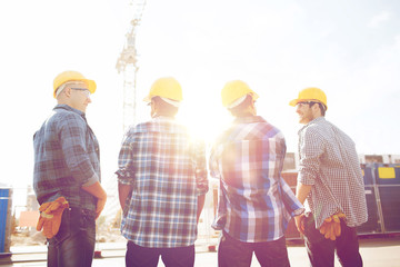 group of smiling builders in hardhats outdoors