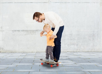 happy father and little son on skateboard