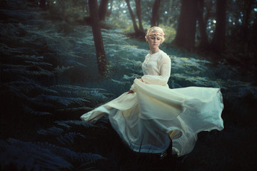 Ethereal woman dancing in dreamy forest