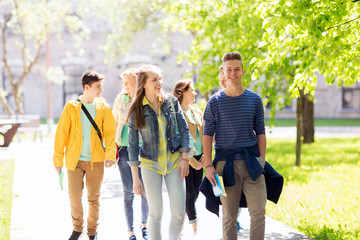 group of happy teenage students walking outdoors