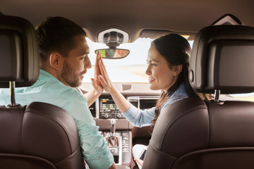 happy man and woman driving in car