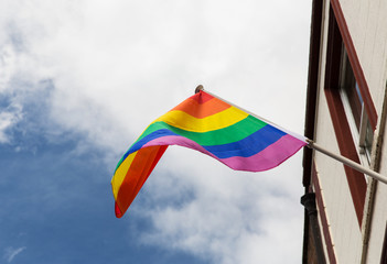 close up of rainbow gay pride flag waving on building