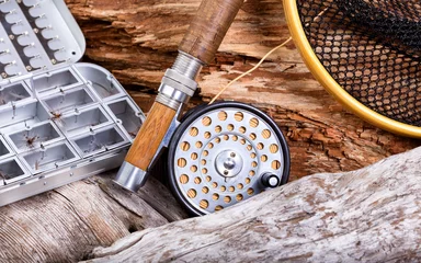 Poster Vintage fly fishing outfit and gear on rocks and wood background © tab62