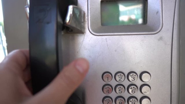 Payphone. Close up of a hand taking an outdoor pay phone hd