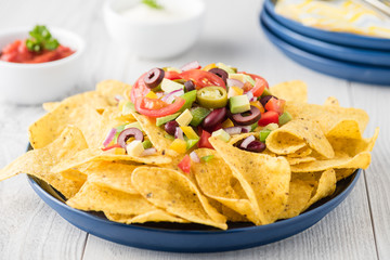 Vegetarian nachos with salsa and sour cream dips