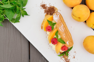 choux pastry with raspberry and apricot. Modern supply of gold a
