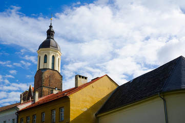 Fototapeta na wymiar Concathedral of the Assumption of the Virgin mary, Opava, Silesia, Czech Republic / Czechia - beautiful gothic religious building with tower made in baroque style. Roofs of small houses in foreground