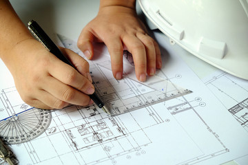 Close up man working of Architect sketching a construction project on his plane project at site construction work