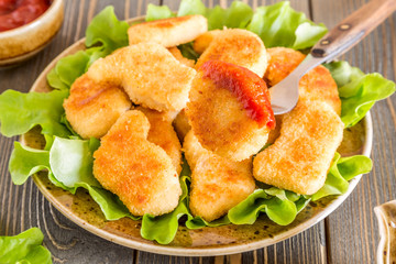 Chicken nuggets with ketchup.