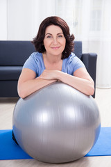 portrait of slim sporty mature woman doing exercises with fitnes