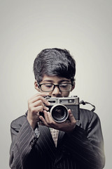 Fototapeta premium Child photographer holding a camera indoor