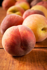 Fototapeta na wymiar Fresh peaches on a wooden table, closeup