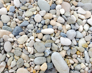 Small pebbles on the beach create pattern, gray tones