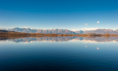 Fototapeta premium Quiet mountain lake horizon with hills and blue sky