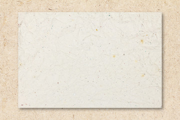 Recycled crumpled white paper on chipboard background with copy space for text or image.