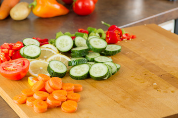 cut vegetables for a salad on a wooden board in the kitchen