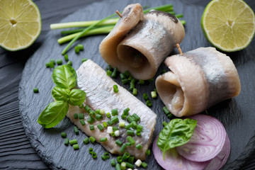 Herring rolls with red and green onion, lime and basil, close-up