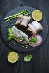Above view of herring fillet rolls with onion, lime and basil