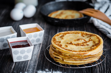Delicious pancakes with jam on a wooden table