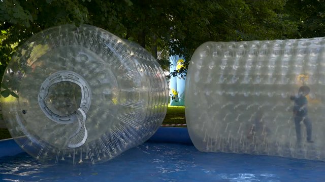 Two zorb balls on the swimming pool outside the yard of the house