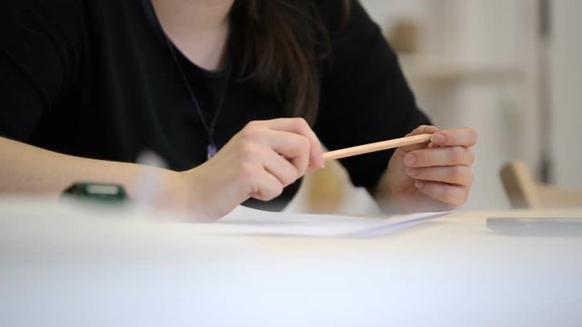 Close-up view of woman holding pencil and talking.