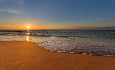 Sunrise light shining on ocean waves.
