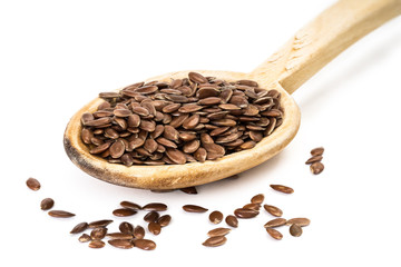 Obraz premium Linseed on a wooden spoon seen from the front on white background