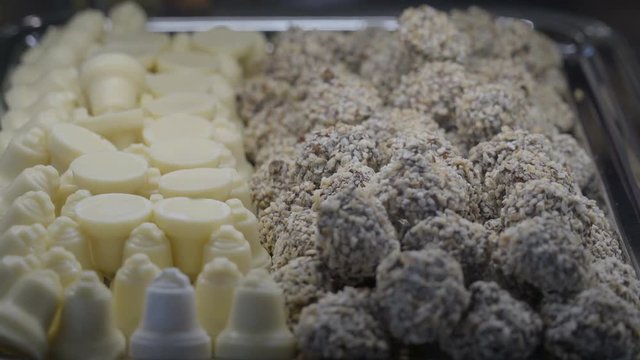 Two sets of desserts in the chaping dish there are the white bell chocolates and the choco balls