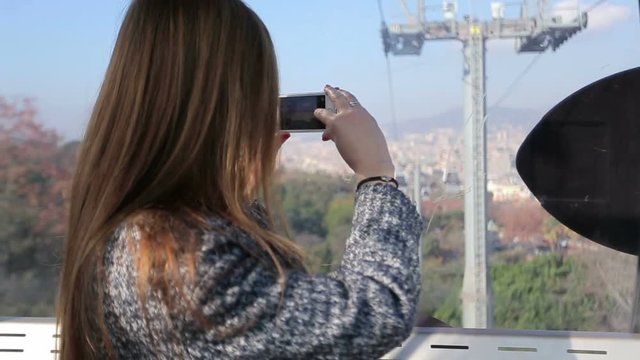 Female in funicular take picture of city view