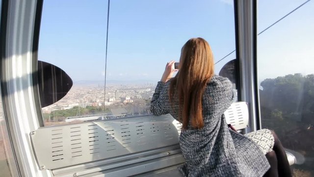 Woman in funicular make photo of city view