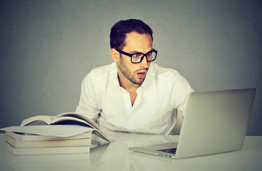 young surprised business man working with laptop