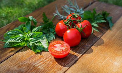 Tomatoes on a wooden board, with herbs. The concept of healthy eating.