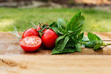 Tomatoes on a wooden board, with herbs. The concept of healthy eating.