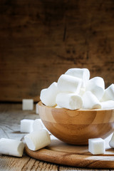 Fototapeta na wymiar Large marshmallows in a wooden bowl, selective focus