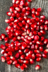 pomegranate seeds on wooden surface