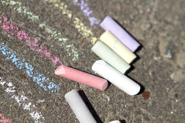 colorful pieces of chalk on the pavement close up in summer