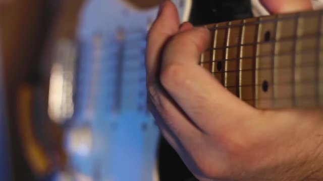 A man playing on electric guitar pentatonic scale in the recording studio close-up