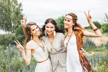 Three beautiful cheerful hippie girls, best friends, the outdoors, cute smile, trendy hairstyles,...