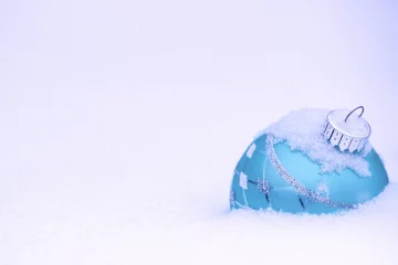  Teal blue Christmas ornament buried in snow © laurha