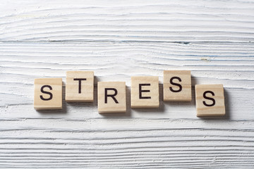 STRESS word written on wood abc cubes at wooden background