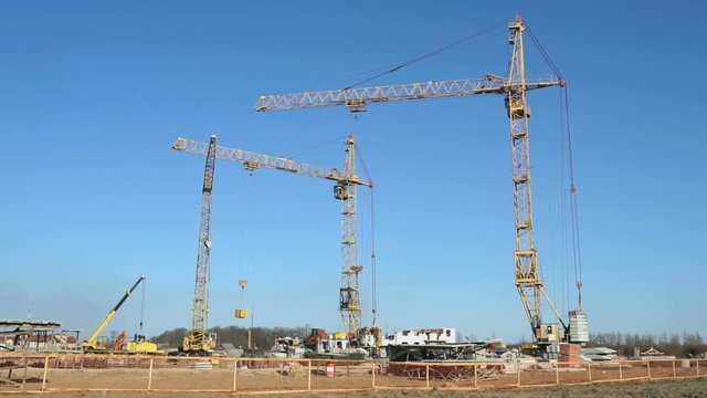 Four construction cranes working on the site