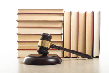 Law concept - Book with wooden judges gavel on table in a courtroom or enforcement office.