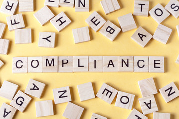 Compliance word written on wood block. Wooden abc