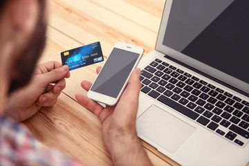 Man hands using credit card and phone for online shopping