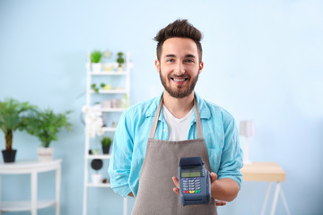 Happy man holding bank terminal in shop