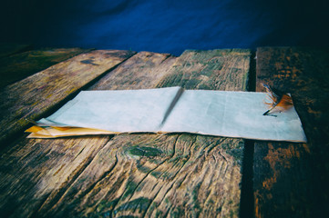 Feather and paper old wooden background