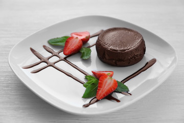 Chocolate fondant with strawberry on plate, closeup