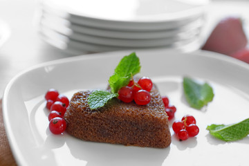 Delicious fondant with red currant on plate, closeup