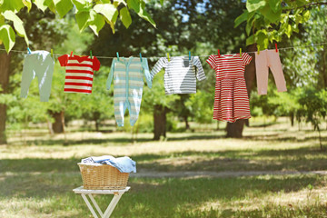 Wicker basket and baby laundry hanging on clothesline